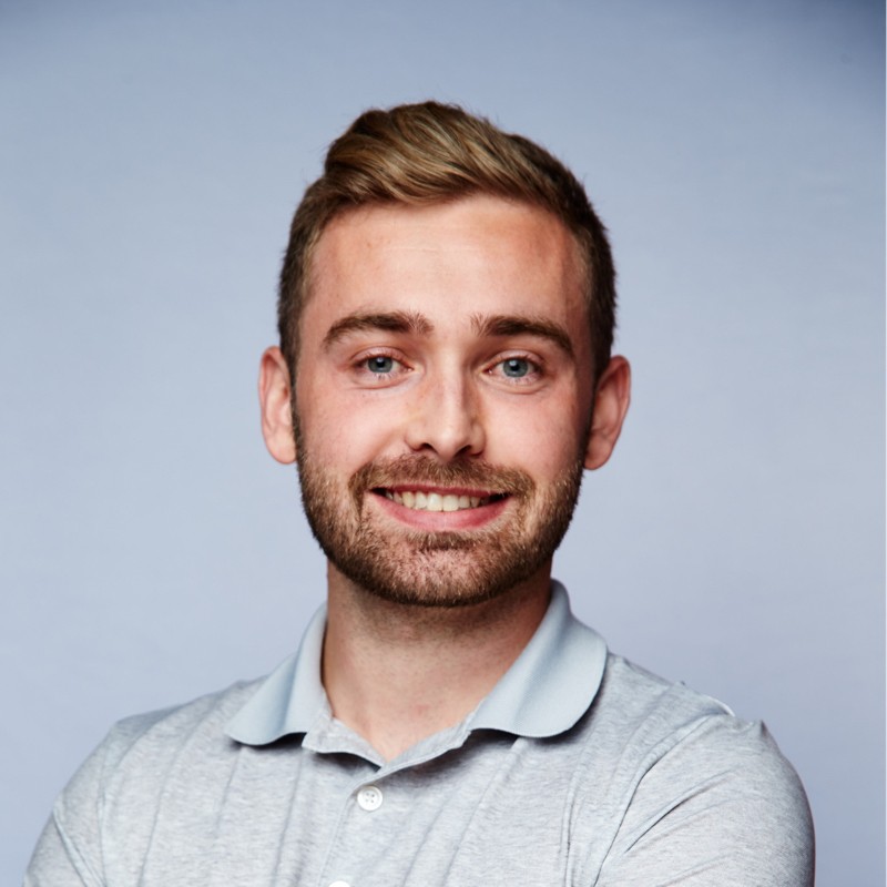 Ryan Cohn in front of a blue background